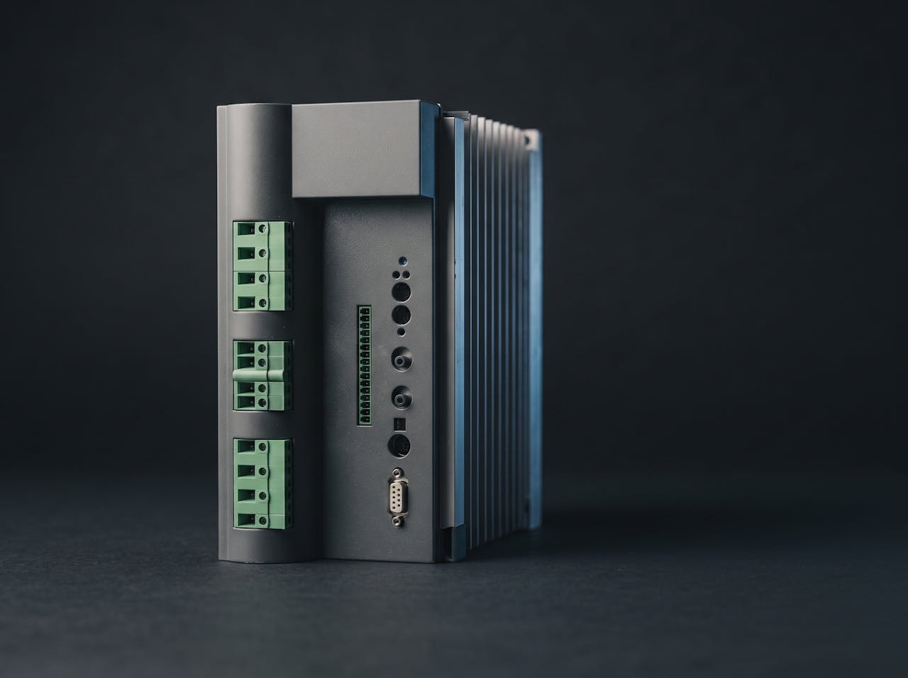 An industrial variable speed drive on a workbench, terminal blocks and heatsink visible